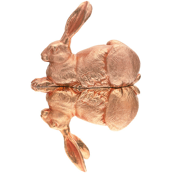 Eine bronzene Kaninchenskulptur, die sich auf einer glänzenden, spiegelähnlichen Oberfläche spiegelt.