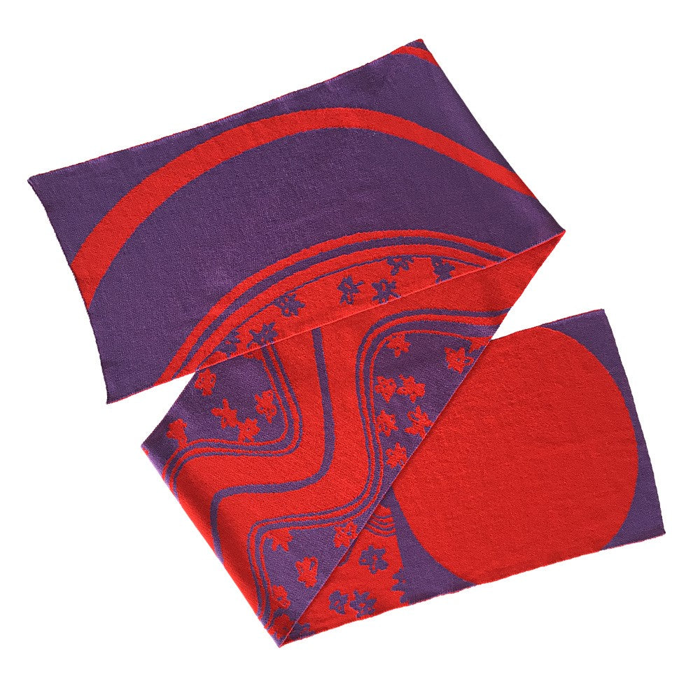 Lila und rot gemusterter Schal mit abstrakten und floralen Designs, flach auf weißem Hintergrund ausgebreitet.