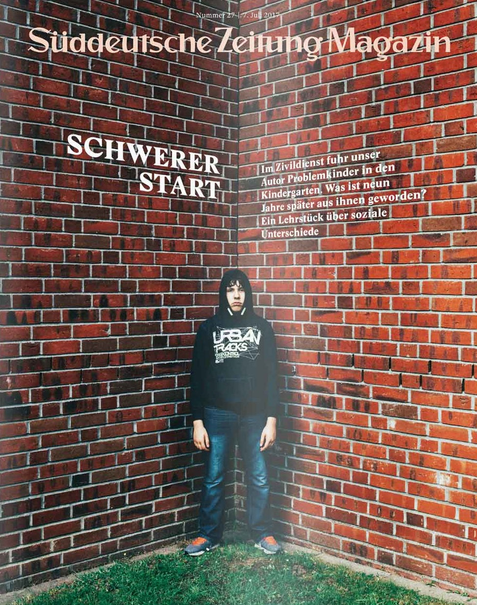 Ein Junge im Kapuzenpulli steht vor zwei sich kreuzenden Backsteinmauern, Titelbild des Süddeutsche Zeitung Magazins.