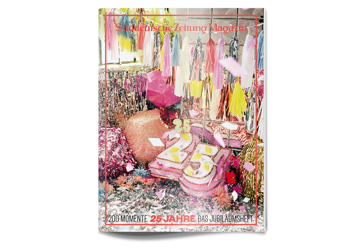 Buntes, festliches Zimmer mit "25"-Torte, Konfetti, Quasten und Partydekoration für ein Zeitschriftenjubiläum.