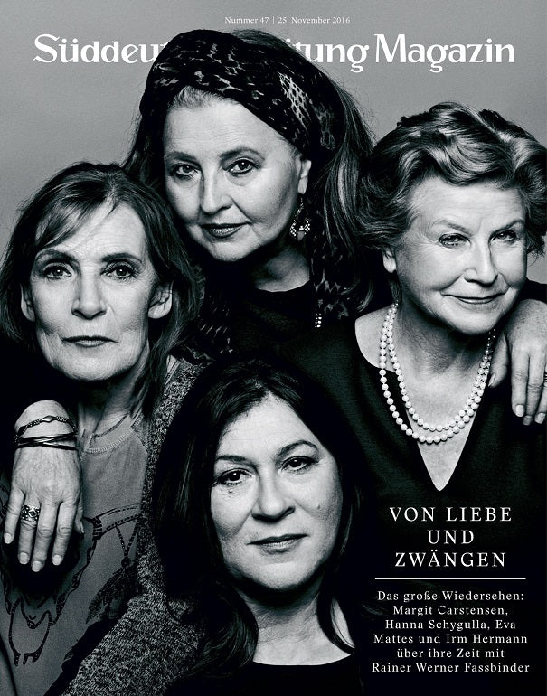Vier ältere Frauen posieren eng beieinander und lächeln für ein Porträt auf dem Cover eines Schwarz-Weiß-Magazins.