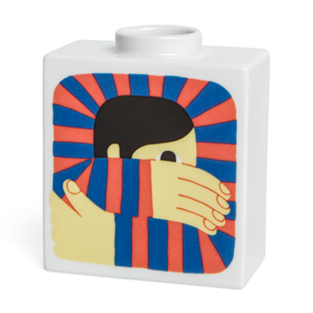 „Introspectus“ von Zeloot 0 ist eine quadratische weiße Vase mit der Grafik einer Person, die ihr Gesicht hinter rot und blau gestreiften Ärmeln versteckt.